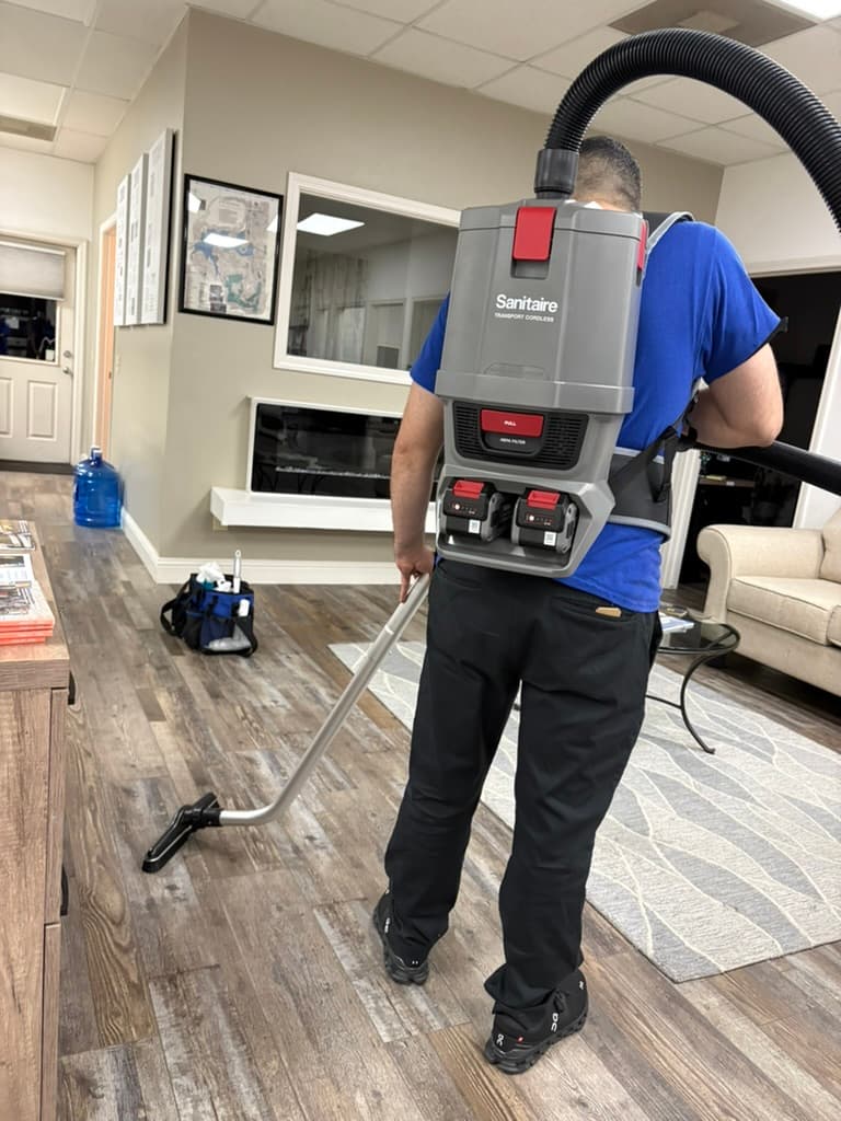 Commercial cleaning technician vacuuming an office
